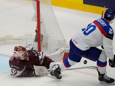 Lotyšský brankár Kristers Gudlevskis chytá nájazd Juraja Slafkovského v zápase Slovensko - Lotyšsko v skupine B na MS v hokeji 2024.